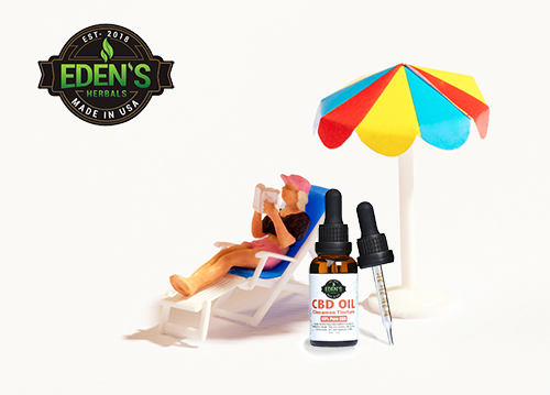 Miniature man in beach chair sun bathing with big bottle of Eden's Herbals CBD Oil next to him
