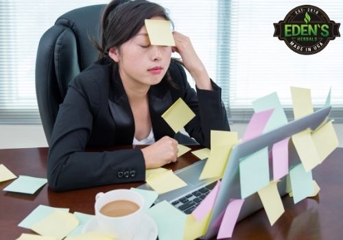woman sitting at her desk stressed out covered in sticky notes