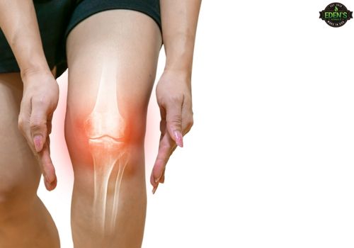 woman holding hands around knee that is highlighted red to show inflammation