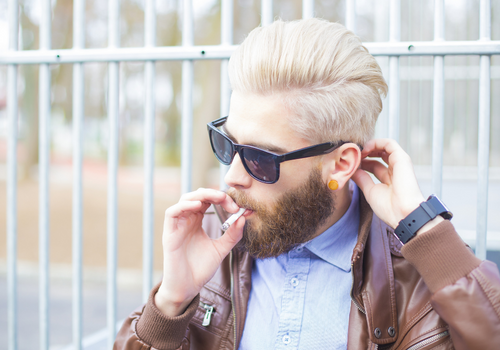 Blonde haired California man smoking a cannabis joint in public
