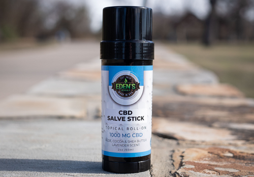 Closeup of CBD salve stick sitting in the middle of a path outdoors