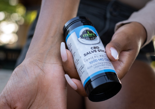 Closeup of cbd salve stick being rubbed onto womans arm
