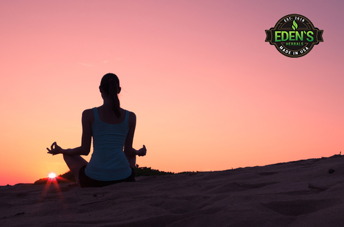 Woman meditating at sunset to relax mind