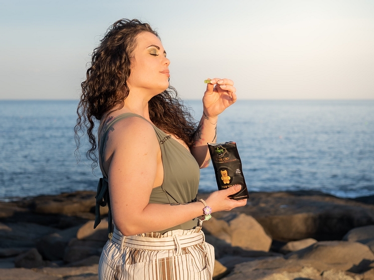 Woman using THC-free CBD gummies for social anxiety relief