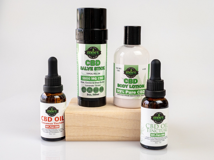 Display of CBD oil, lotion, and hand salve from Eden's Herbals with white background