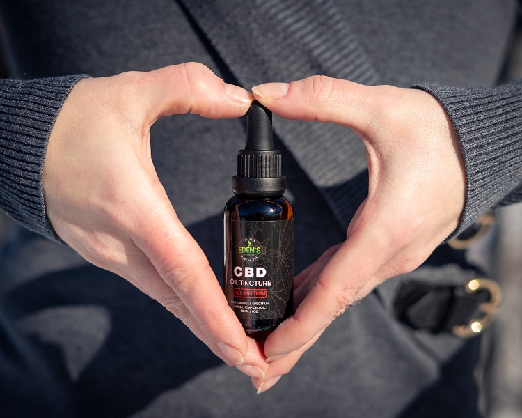 Woman holding CBD oil tincture for reducing anxiety
