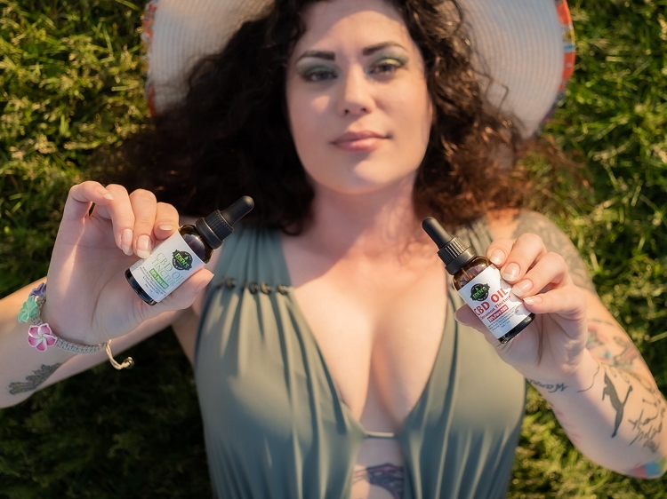 Woman holding up CBD tinctures for OCD management