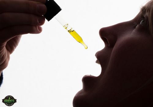 woman holding cbd dropper to mouth to take dose of CBD oil