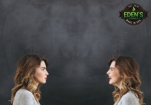 woman staring at reflection with one face happy and one angry