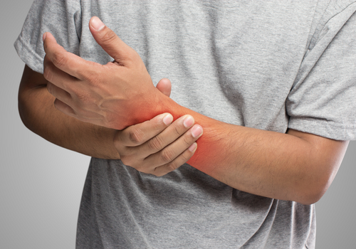 Man holding wrist with red glow representing pain he is experiencing