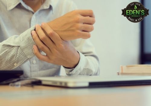 man at his desk holding his wrist from carpal tunnel pain