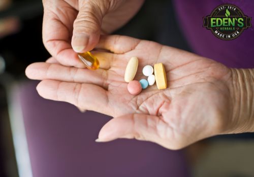 Person holding daily medication in hand with CBD capsule