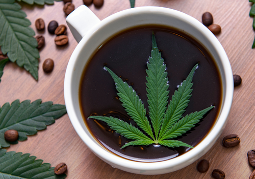 Overhead shot of a cup of coffee with a cannabis leaf floating in it