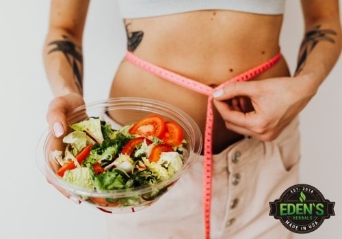 Woman Measuring Waste Eating A Salad With CBD For Appetite