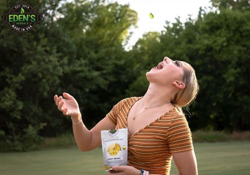 woman tossing eden's herbals cbd gummies into her mouth