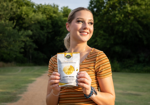 Young woman holding up bag of cbd gummies