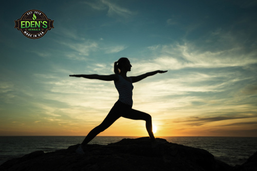 Woman creating healthy lifestyle by doing yoga at sunrise