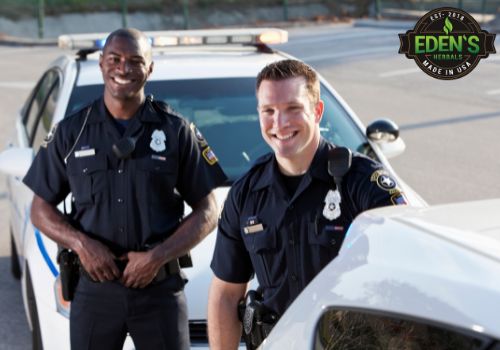 two police officers standing outside of their cruisers