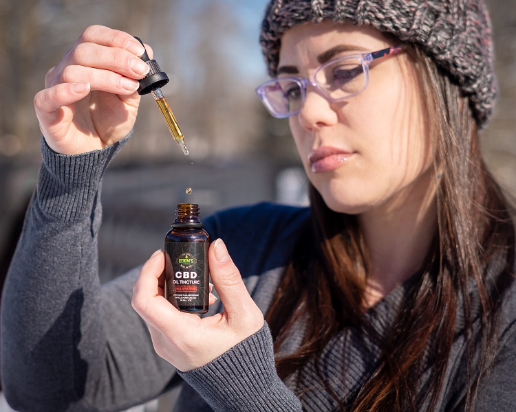 Woman using CBD oil tincture to destress