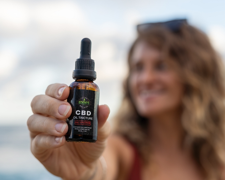 Woman holding up full spectrum cbd for nausea relief