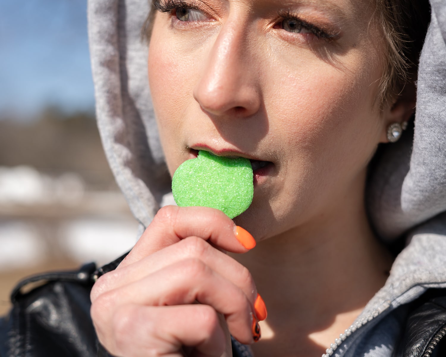 Woman eating a sour apple flavored cbd gummy