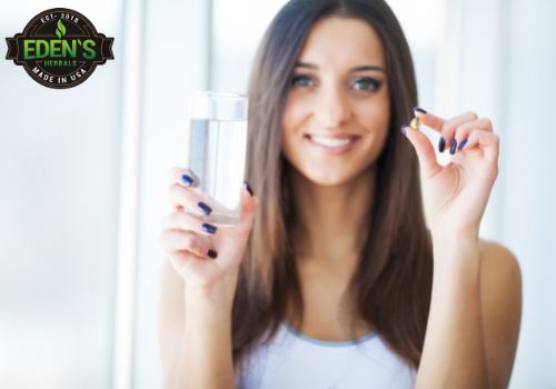 Woman taking a daily multi vitamin with a glass of water