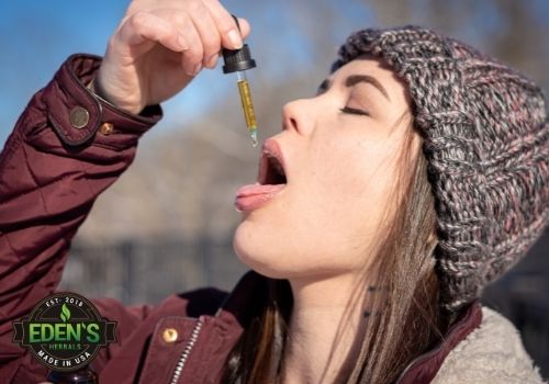 Woman taking CBD Oil under tongue