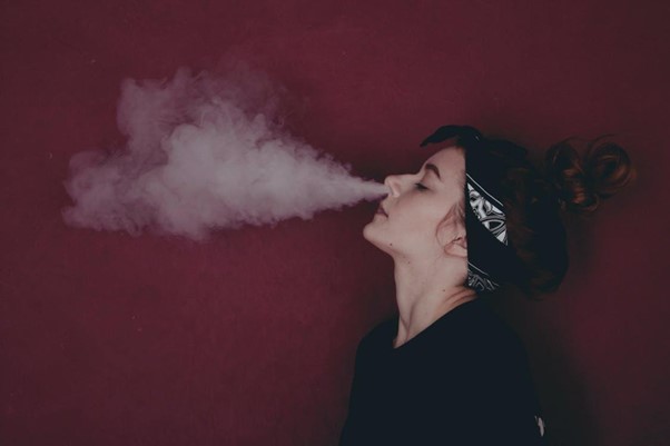 Woman blowing smoke from vape device